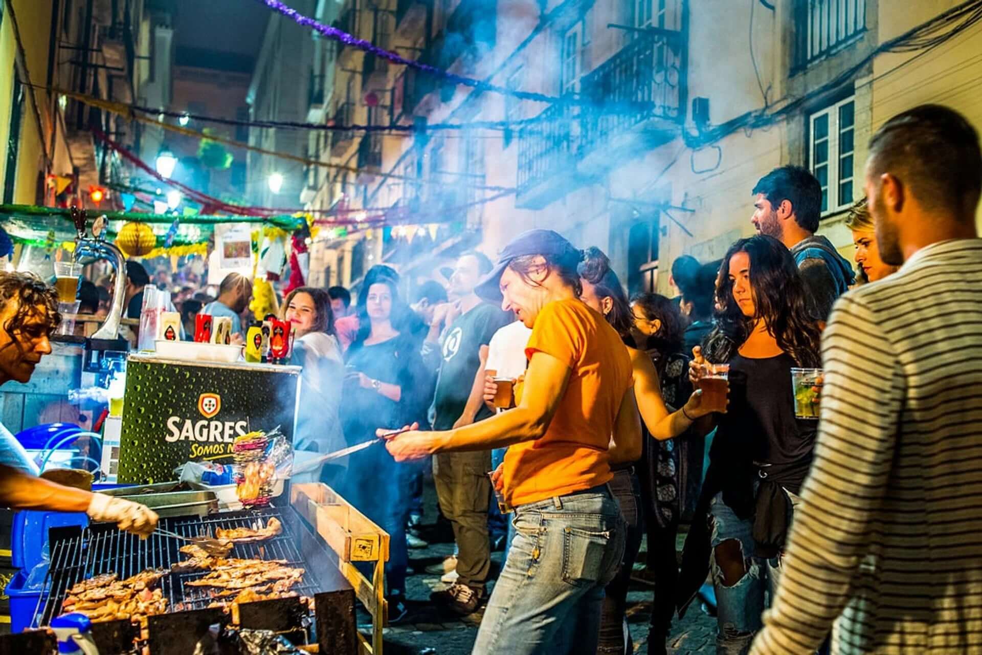 Personnes autour d'un stand de sardines grillées lors de fêtes des Saints Populaires au Portugal